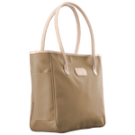 Beige tote bag with white handles on a black background