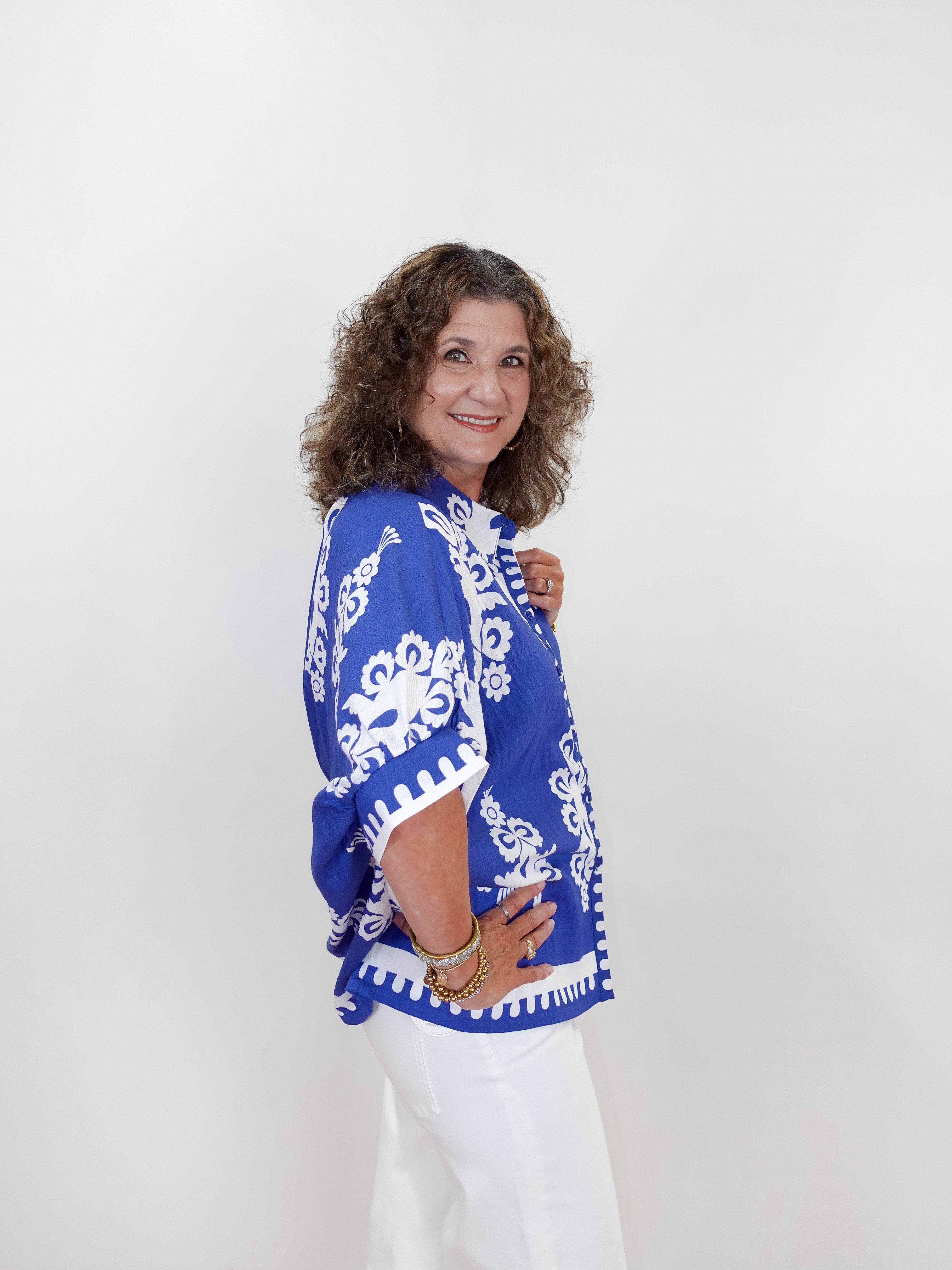 Woman wearing a blue and white patterned top against a white background