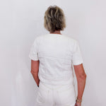 Person wearing a white outfit against a plain background