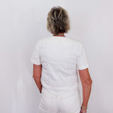 Person wearing a white outfit against a plain background
