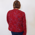 Person wearing a red patterned shirt against a white background