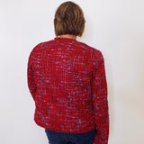 Person wearing a red patterned shirt against a white background