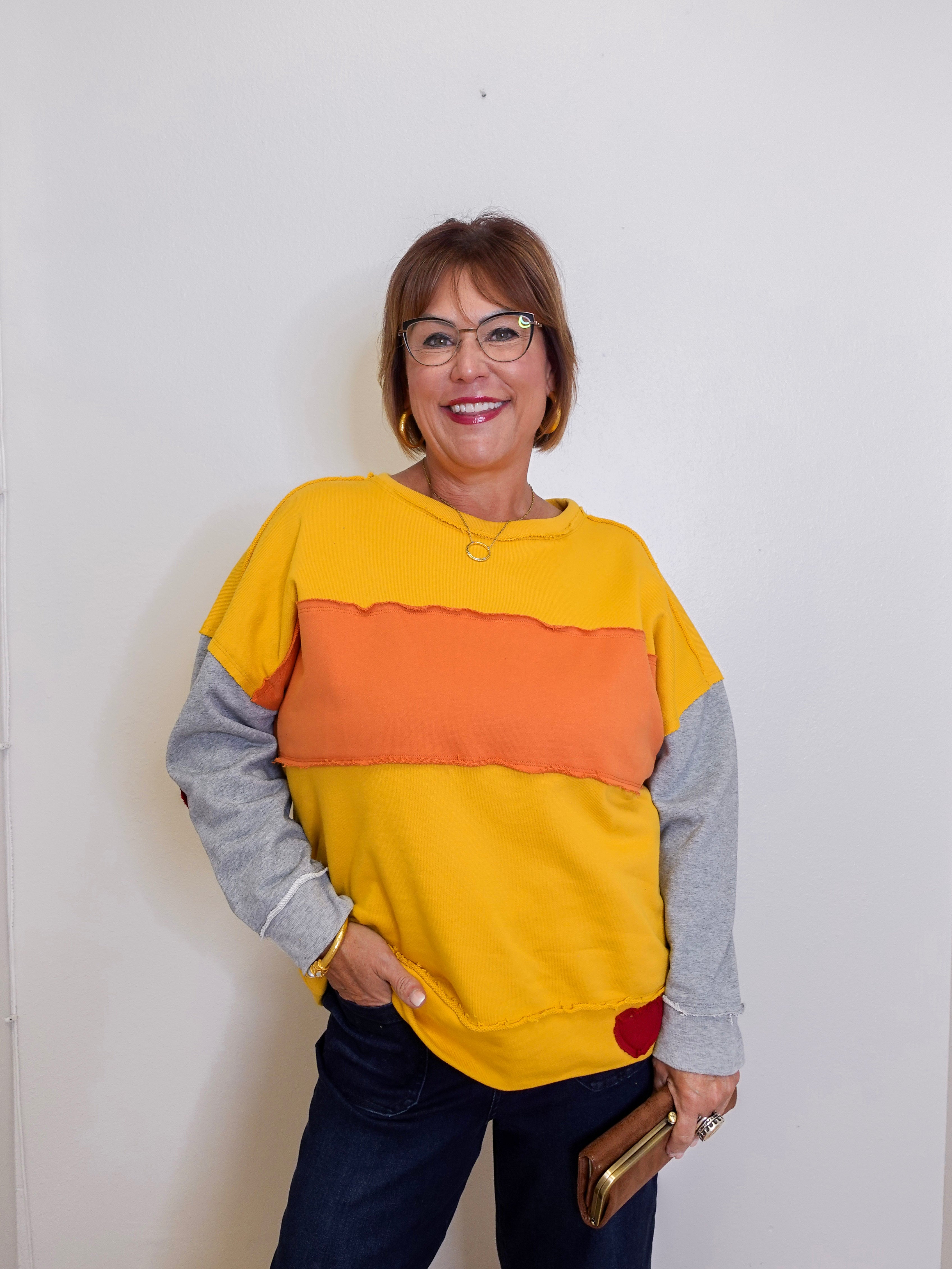Woman wearing a colorful sweater with a plain background