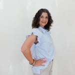 Woman wearing a light blue blouse against a white background