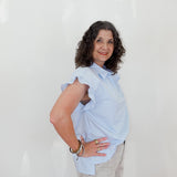 Woman wearing a light blue blouse against a white background