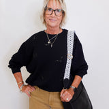 woman wearing a black sweatshirt that has black sequin bats on it