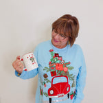 woman wearing a blue knit top against a white background. 
