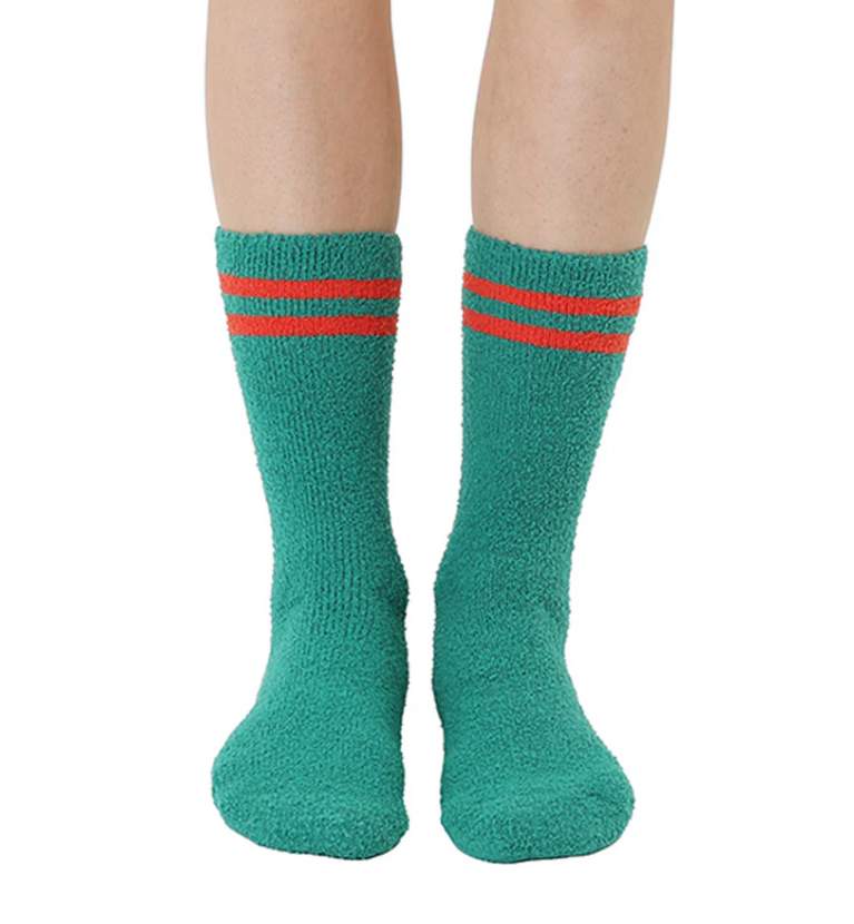 Green socks with red stripes worn by a person on a white background