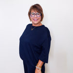 Woman wearing a navy blue dress with a white background