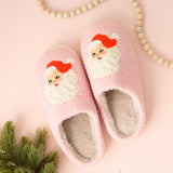 Pink slippers with Santa face design on a pink background
