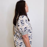 Woman wearing a patterned shirt against a plain background