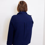Person wearing a navy blue jacket against a white background