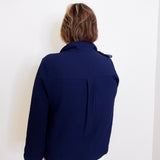Person wearing a navy blue jacket against a white background