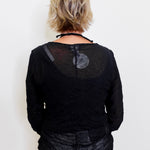 Person wearing a black textured top against a white background
