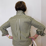 Person wearing a green and white striped shirt against a plain background