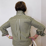 Person wearing a green and white striped shirt against a plain background
