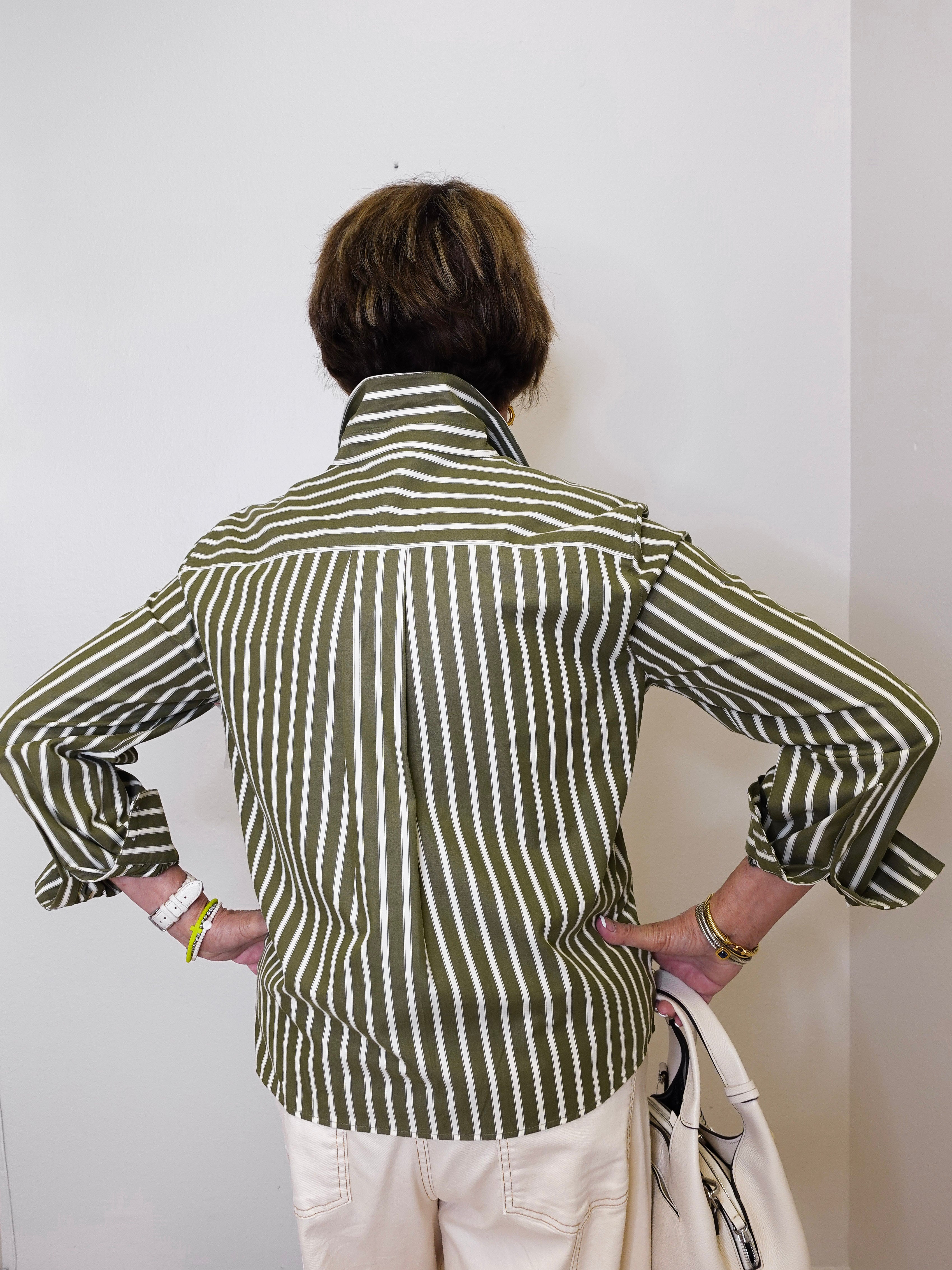 Person wearing a green and white striped shirt against a plain background
