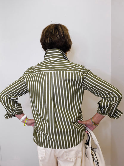 Person wearing a green and white striped shirt against a plain background