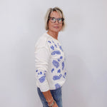 woman styled in johnny was daniela patchwork thermal long sleeve top with blue embroidery and jeans