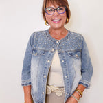 Woman wearing a denim jacket with a plain background