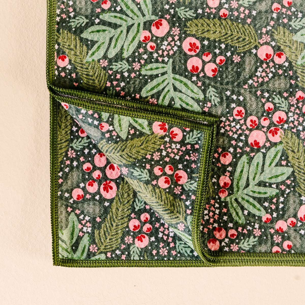 Floral patterned fabric with green leaves and pink flowers on a beige background