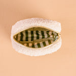 White textured pouch with a gold zipper on a beige background