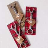 Set of three silver bottle openers with deer heads on plaid paper packaging.