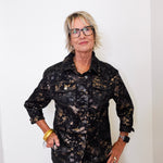 Woman wearing a black floral jacket against a white background