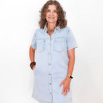 Woman wearing a light blue denim dress on a white background