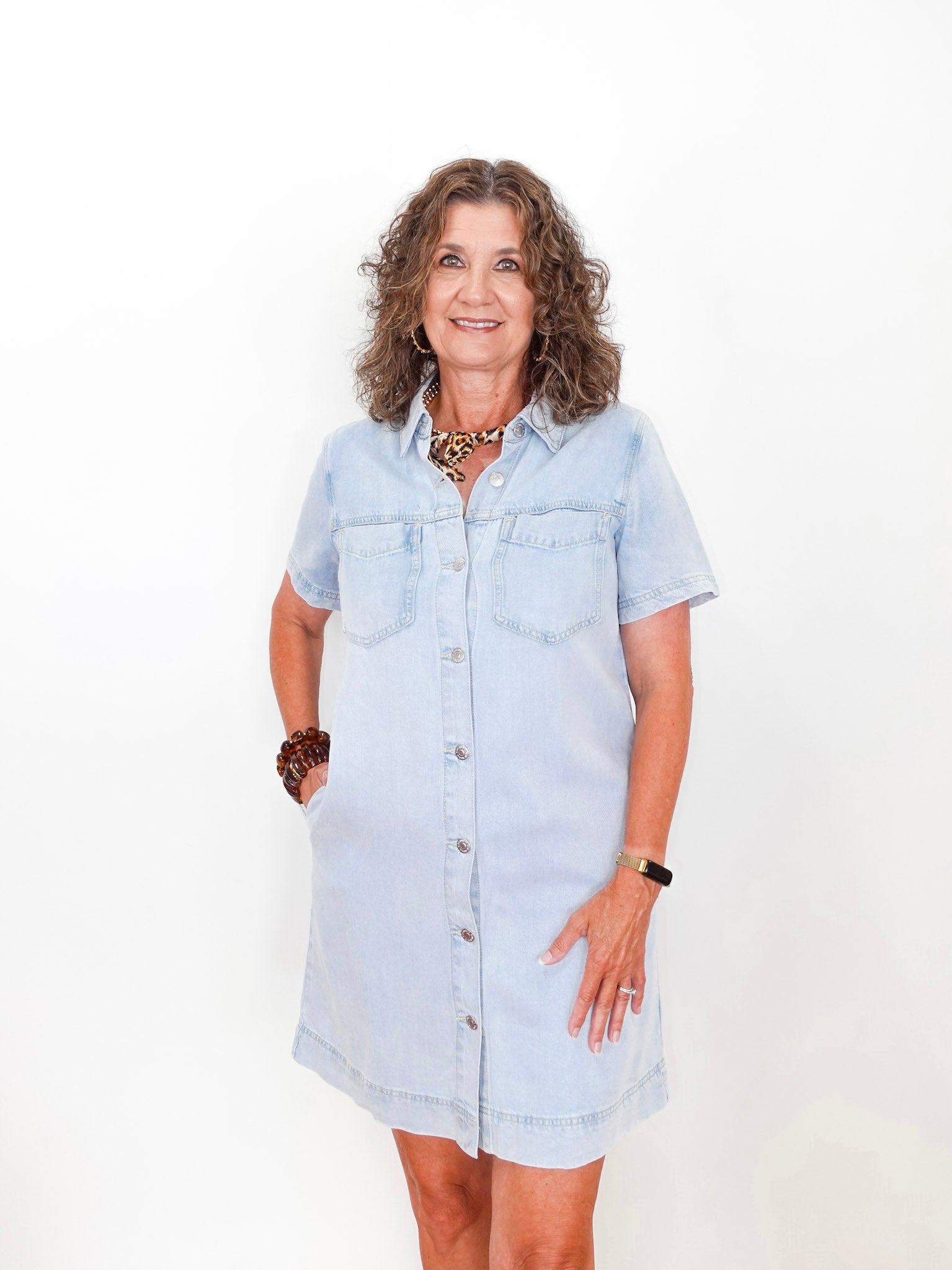 Woman wearing a light blue denim dress on a white background