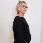 Person wearing a black sweater against a white background