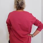 Person wearing a red long-sleeve shirt against a white background