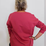 Person wearing a red long-sleeve shirt against a white background