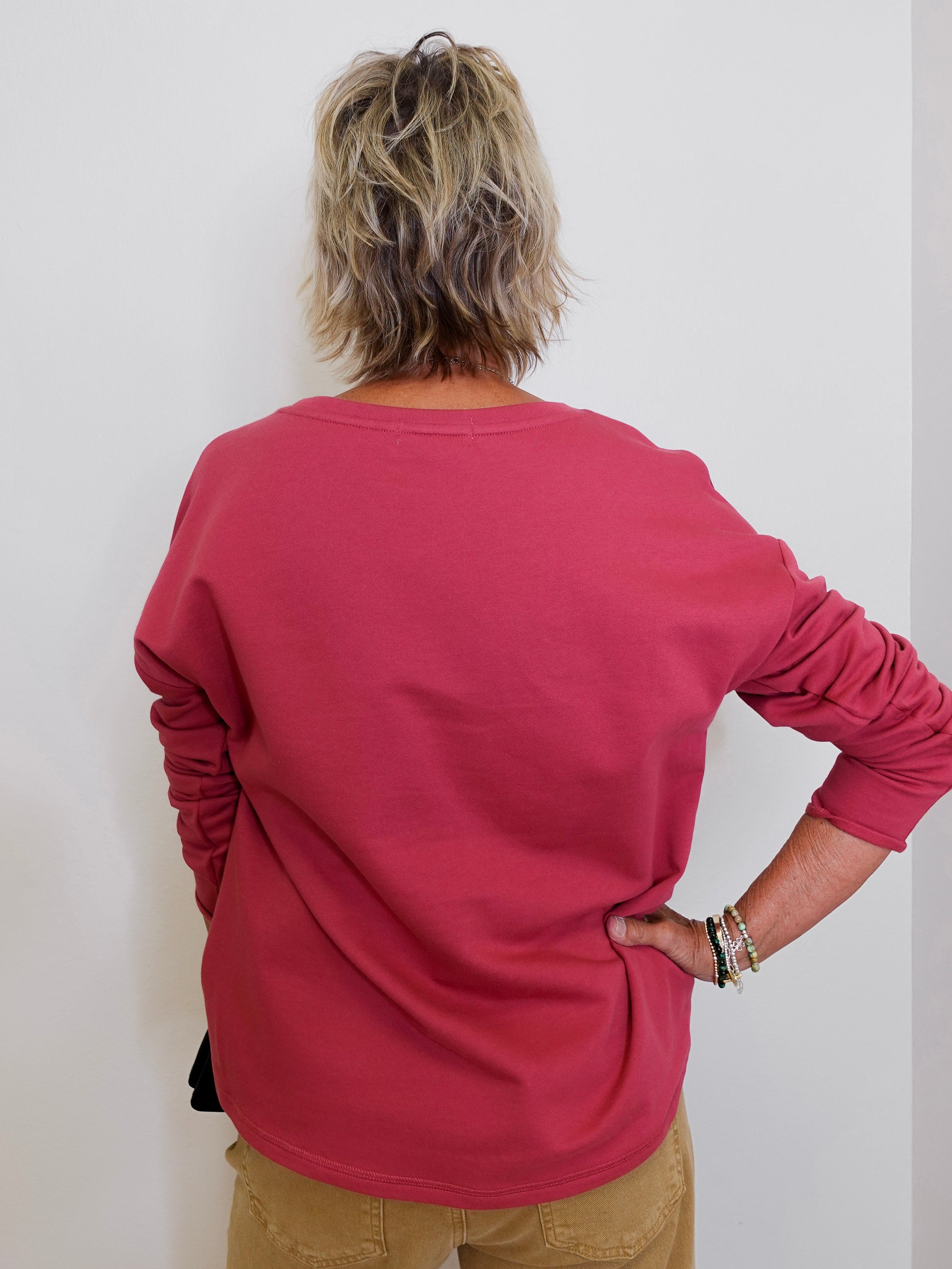 Person wearing a red long-sleeve shirt against a white background