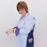 Woman wearing a blue and white striped shirt with a navy cardigan over a white background