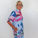 Woman wearing a colorful patterned dress with a white background