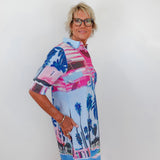 Woman wearing a colorful patterned dress with a white background