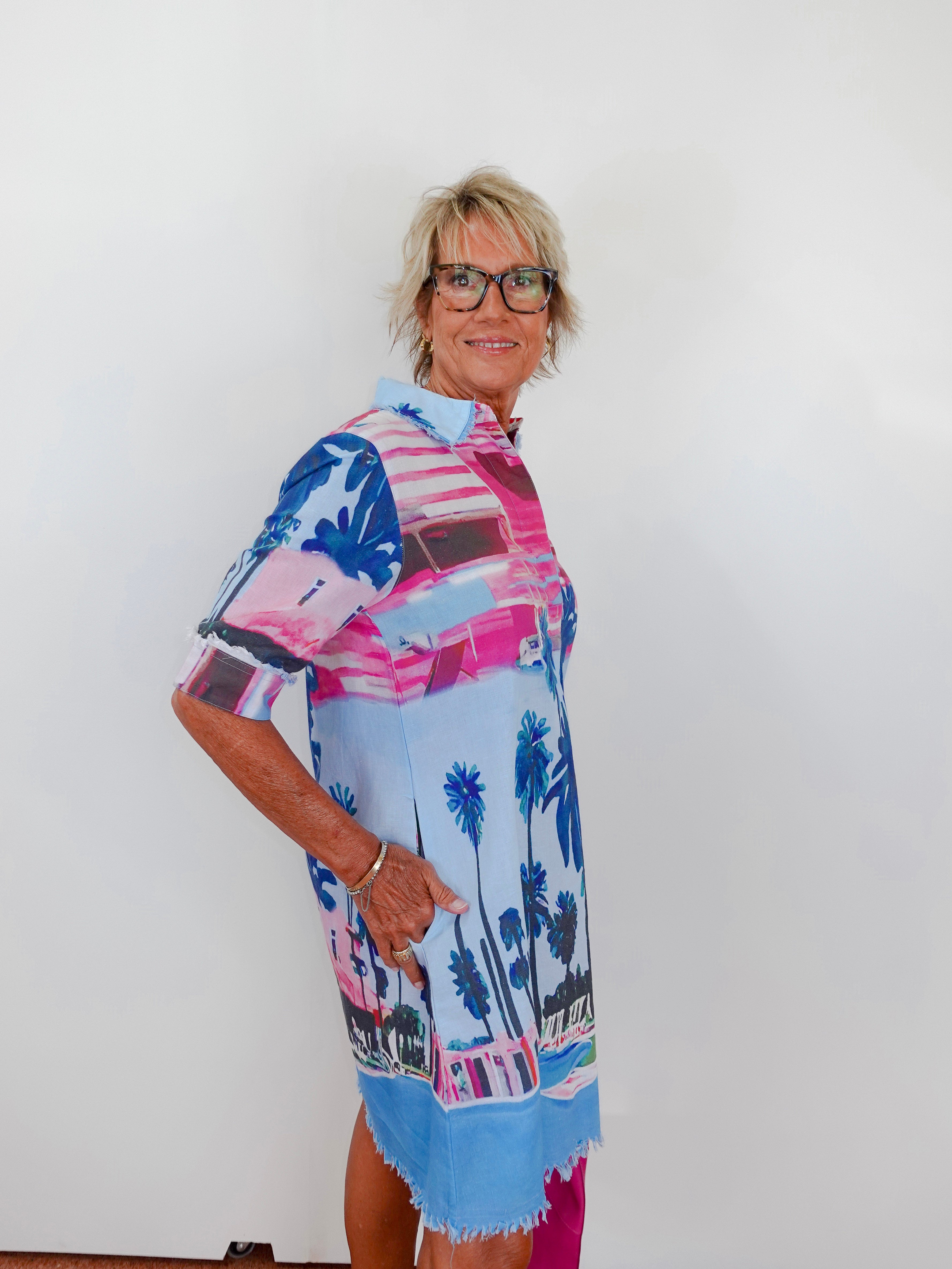 Woman wearing a colorful patterned dress with a white background
