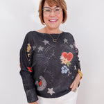 Woman wearing a dark sweater with colorful patterns on a white background