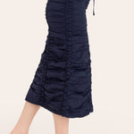 Navy blue ruched skirt worn by a person on a white background