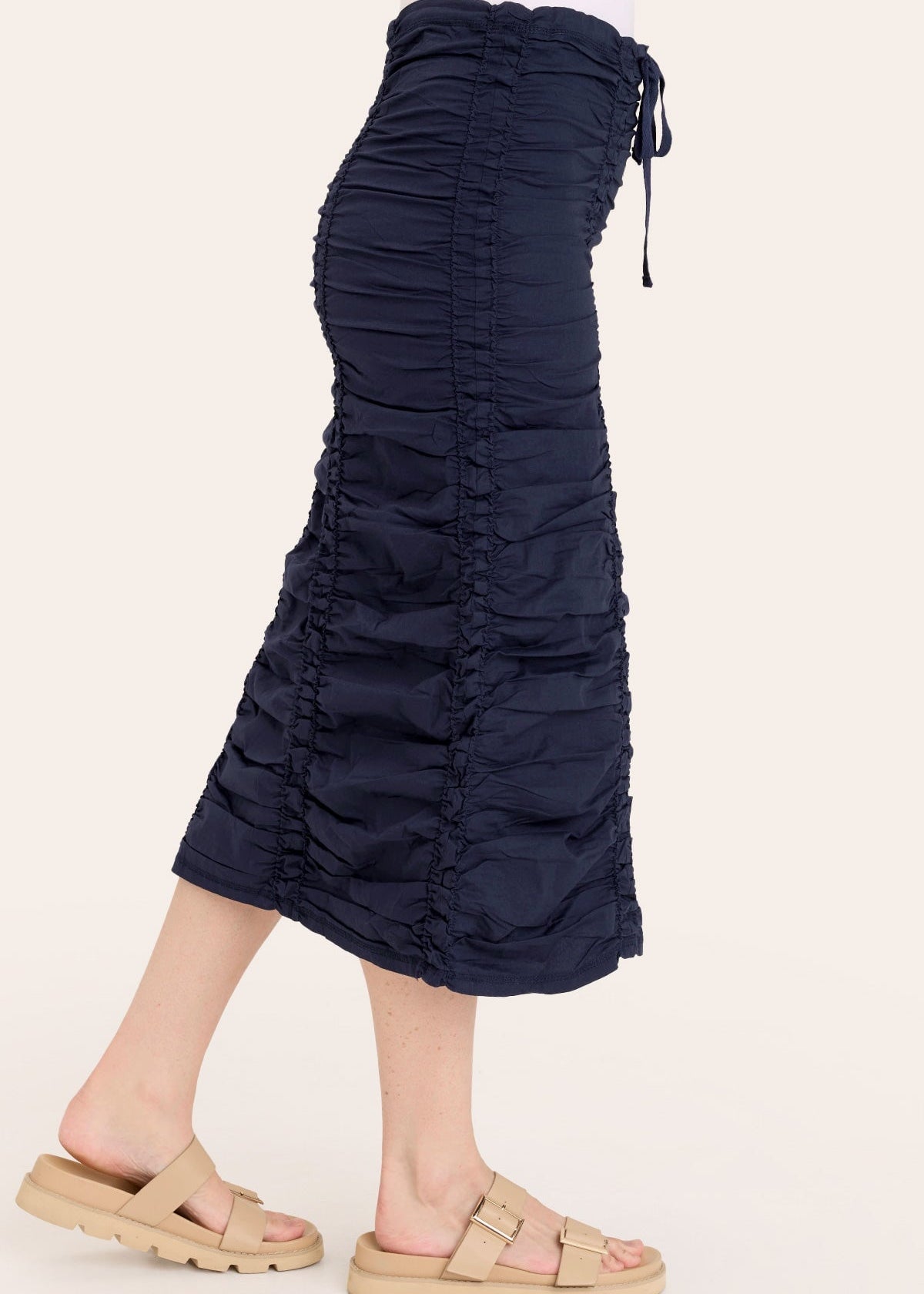 Navy blue ruched skirt worn by a person on a white background