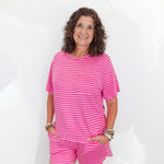 Woman wearing a pink striped outfit against a white background