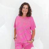 Woman wearing a pink striped outfit against a white background