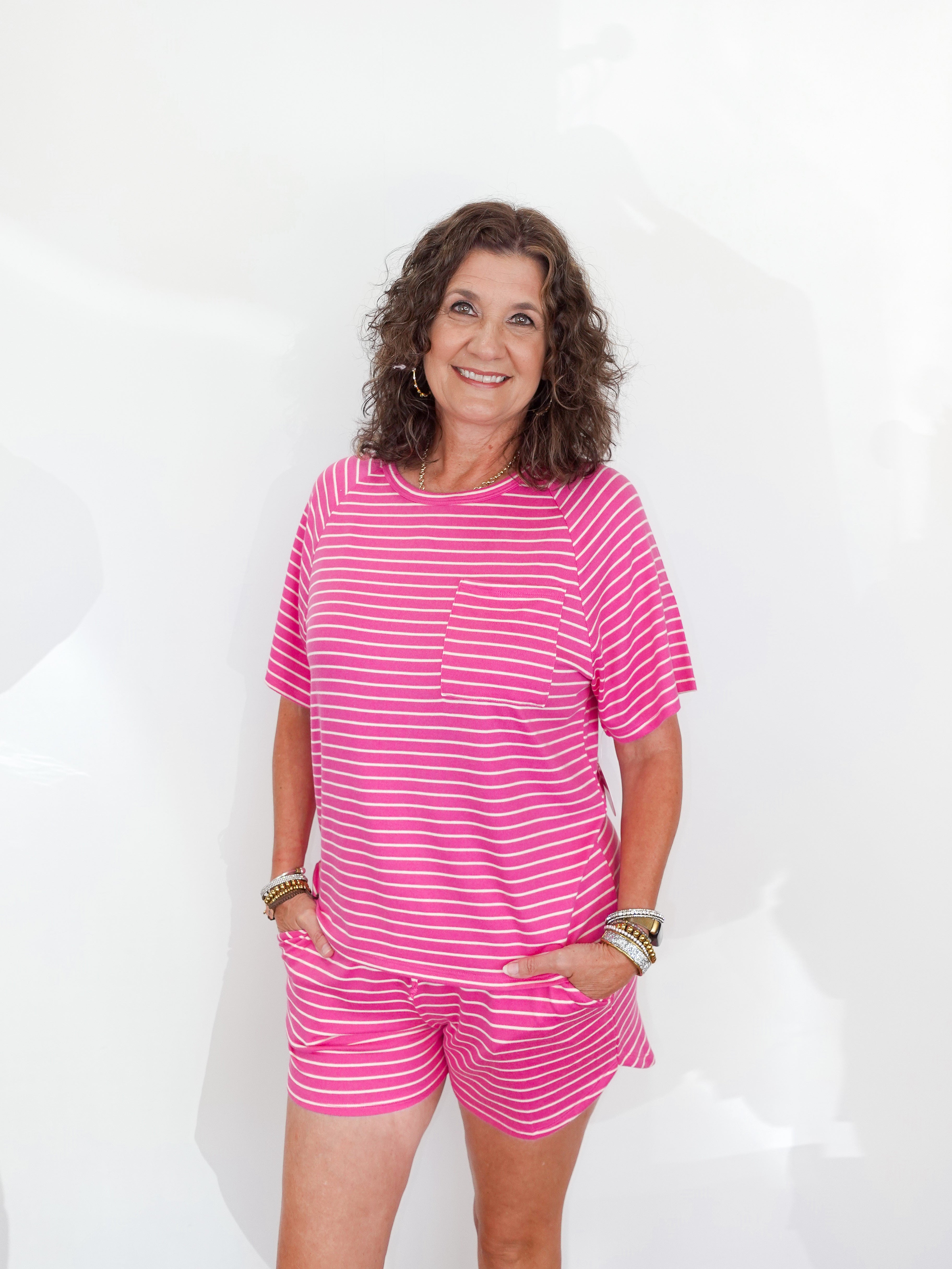 Woman wearing a pink striped outfit against a white background