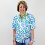Woman wearing a floral blouse with a plain background