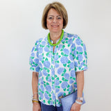 Woman wearing a floral blouse with a plain background