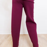 Maroon tracksuit worn by a person on a light wooden floor.