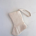 Beige fabric stocking on a light gray background