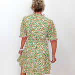 Person wearing a floral dress against a white background