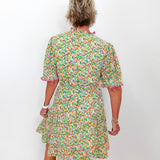 Person wearing a floral dress against a white background